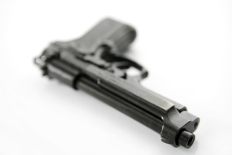 Black hand gun pistol over white background, selective focus, studio shot