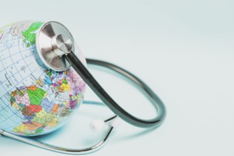Globe care with stethoscope blue background