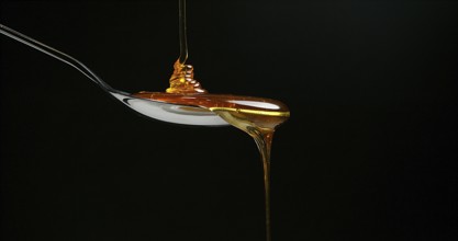 Honey Flowing against Black Background