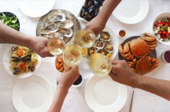 People fine dining seafood and white wine on the table. Top view