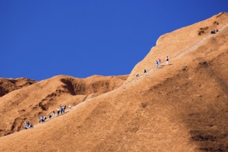 Uluru, Australia, July 4, 2015: Climbers ascend Uluru against the wishes of the Aborginal land
