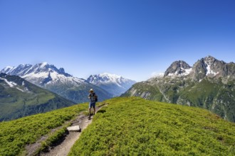 Mountaineer on hiking trail, mountain panorama with glaciated mountain peaks, Aiguille Verte with