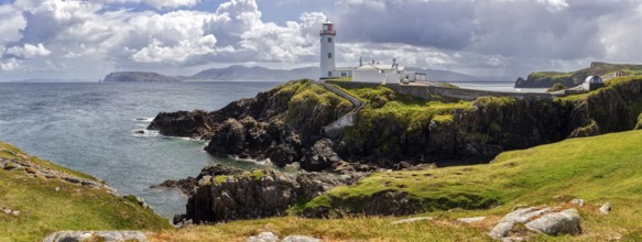 Lighthouse on cliffs by the sea under a dramatic cloudy sky, Fanad Head Lighthouse