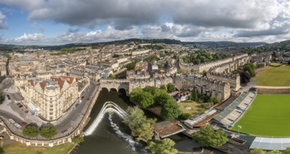 Panorama of a city with river and historic buildings under a cloudy sky, Bath