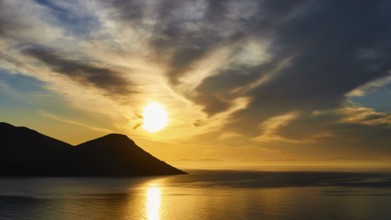 Sunrise by the sea with mountains, dramatic clouds and golden light, Mani Peninsula, Peloponnese,