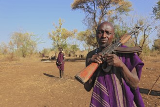 South Ethiopia, in the Maco National Park, in the village of the Mursi, Mursi man with rifle,