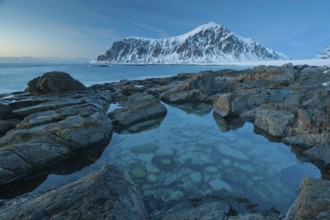 Long exposure, winter at Skagsanden, rocks washed over by the sea on the beach at Flakstad,