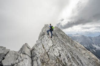 Mountaineer on a narrow rocky ridge, Watzmann crossing to Watzmann Mittelspitze, view of mountain