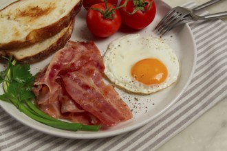 Breakfast, fried egg, bacon and bread, with cherry, on a light background, homemade, no people