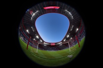 Overview, interior, floodlit match, behind-the-goal perspective, goal net, blue hour, fisheye shot,