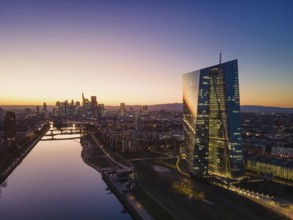 The lights in the offices of the European Central Bank (ECB) and the Frankfurt skyline glow in the
