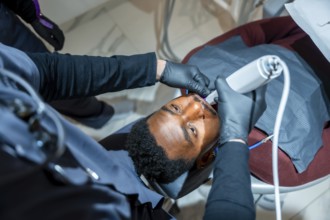 Dentist uses a professional teeth whitening lamp, enhancing a patient's smile in a state of the art