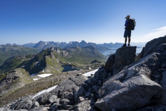 View of mountains and fjord landscape, mountain panorama, mountaineer at the summit of Rundfjellet,