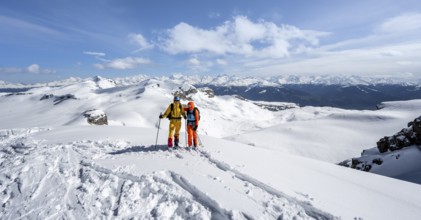 Couple, two ski tourers at the summit Wisshore with mountain panorama, snowy mountain landscape,