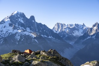 Red tent in front of a mountain panorama, mountain landscape in the morning light, mountain peaks