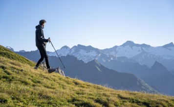 Hiker enjoying the mountain panorama in the morning, Venediger group, behind Dreiherrenkopf,