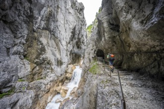 Hammersbach mountain stream in a canyon, mountaineer on a hiking trail in a gorge, Höllentalklamm,