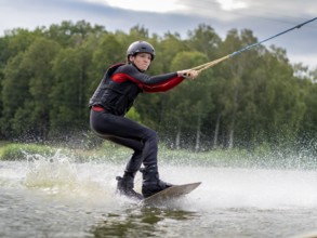 Young man, athletic, fast wakeboarding, water sports, water skiing and wakepark, Stráž pod Ralskem,