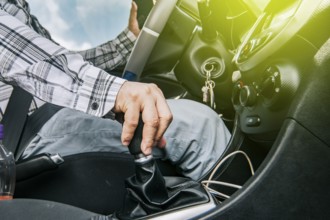 Close up of a man's hand on the gear lever of a car, concept of speed and gear lever, close up of