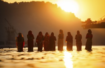 Hindu devotees perform rituals as they offer prayers to the Sun god in the bank of Brahmaputra