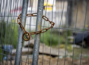 Rusty safety chain on construction fence, Berlin, Germany, Europe