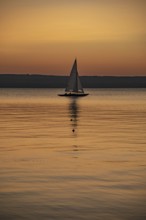 Sailing boat in the sunset with sunset on the Lake Ammer near Herrsching, Bavaria, Germany, Europe