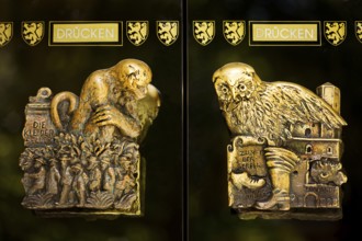 Door handles on the glass doors of the town hall with motifs from the history of the city of
