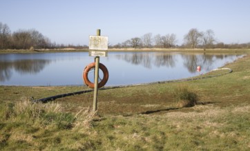 Orange life saving ring by irrigation water reservoir, Sutton, Suffolk, England, United Kingdom,