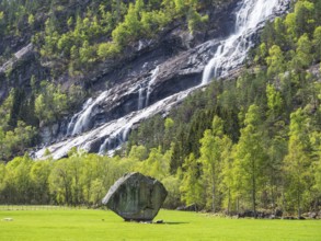 Waterfall Vidfossen, single large rock Oddmundsteinen, south of town Odda at fjord Sørfjord, branch