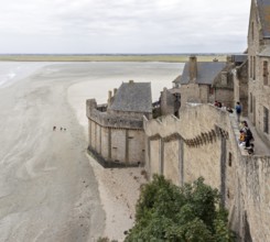 Historic buildings border an extensive sandy beach with views of the sea and the countryside, Le