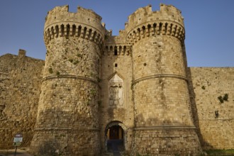 Old-fashioned entrance to a stone castle with tower and entrance gate, sea gate, harbour area,