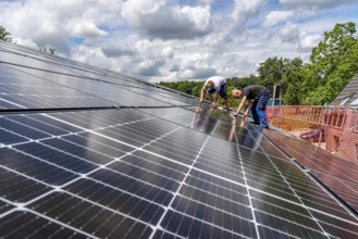 Installation of solar modules on the roof of a barn on a farm, over 210 photovoltaic modules are