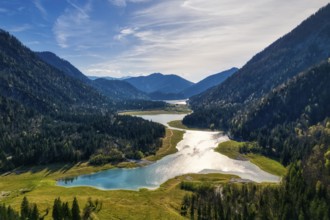 A quiet valley with a lake, surrounded by wooded mountains under a sunny sky, Mittersee
