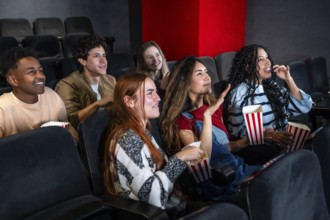 Friends enjoying a film in a movie theater, munching on popcorn and sharing laughter, creating
