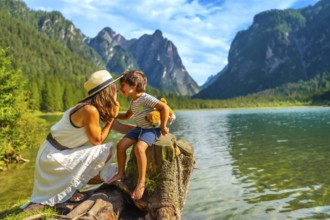 Mother and son sharing a tender moment while enjoying the breathtaking scenery of lake dobbiaco in