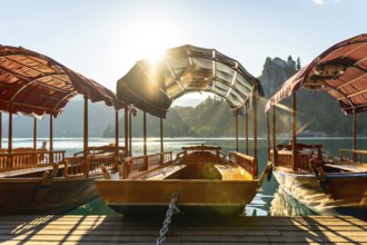 Wooden tourist boats moored at dock on lake bled in slovenia with bled island and iconic church in