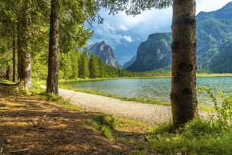 Breathtaking summer view of lake dobbiaco, nestled amidst the majestic dolomites, with a tranquil