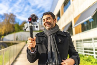 Mature elegant man vlogger smile while recording videoblog content in the city