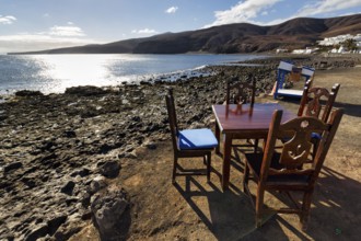 Wooden table and four chairs, fish restaurant on the beach, Playa Quemada, Yaiza, Lanzarote, Spain,