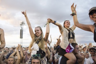 Festival visitors are carried on shoulders during the performance of the band Feine Sahne