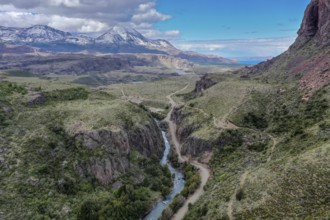 Canyon of river Rio Claro, gravel road along the river, view towards mountain range at Puerto