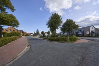 Residential area, residential building, trees, blue sky with fair weather clouds, intersection
