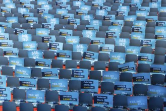 Assembly hall, deserted with many empty chairs and posters with the inscription UNSER KANNZLER.