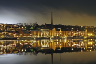 Night view with illuminated waterfront buildings and reflections in the water, winter, ice, capital