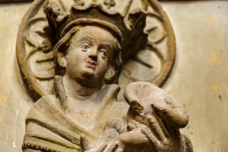 Mother of God with baby Jesus without head, detail of a damaged stone relief of a group of three,