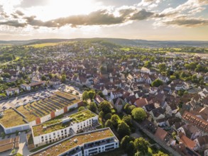 Urban aerial view during sunset with numerous roofs, a church and a hilly landscape, Weil der