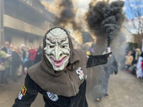 Portrait of Hofener Hogamale with smoke bomb at the big carnival parade of the Hofener