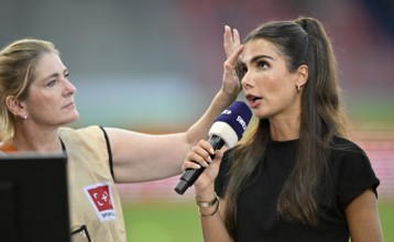 Make-up artist fixes the hair of TV presenter Lea Wagner, in an interview, microphone, mike, logo,