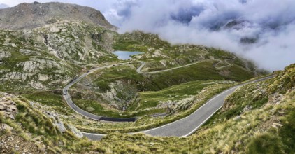 In the foreground a winding pass road to the Colle del Col de Nivolet pass, in the background a