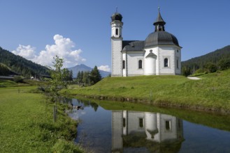 Seekirchl with reflection, Heiligkreuzkirche, view from the parish hill, Seefeld, Tyrol, Austria,